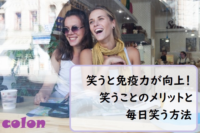 カフェの窓際で笑う外国人女性2人
